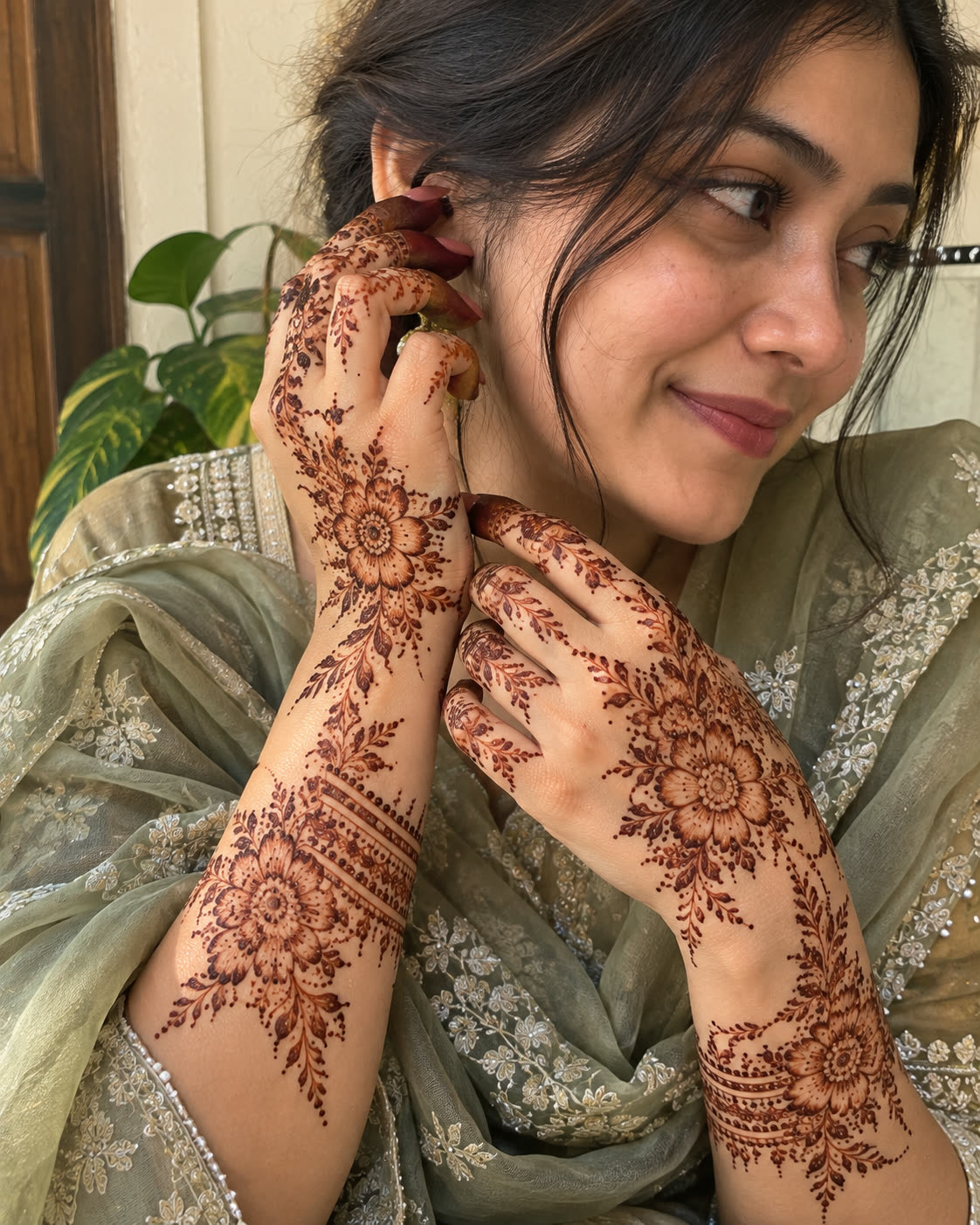 Engagement mehedi on both hands with a sage green outfit