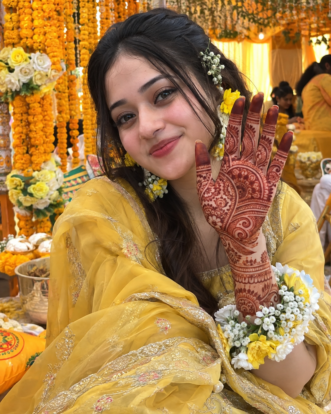 Holud bride in yellow showing her full mehedi palm